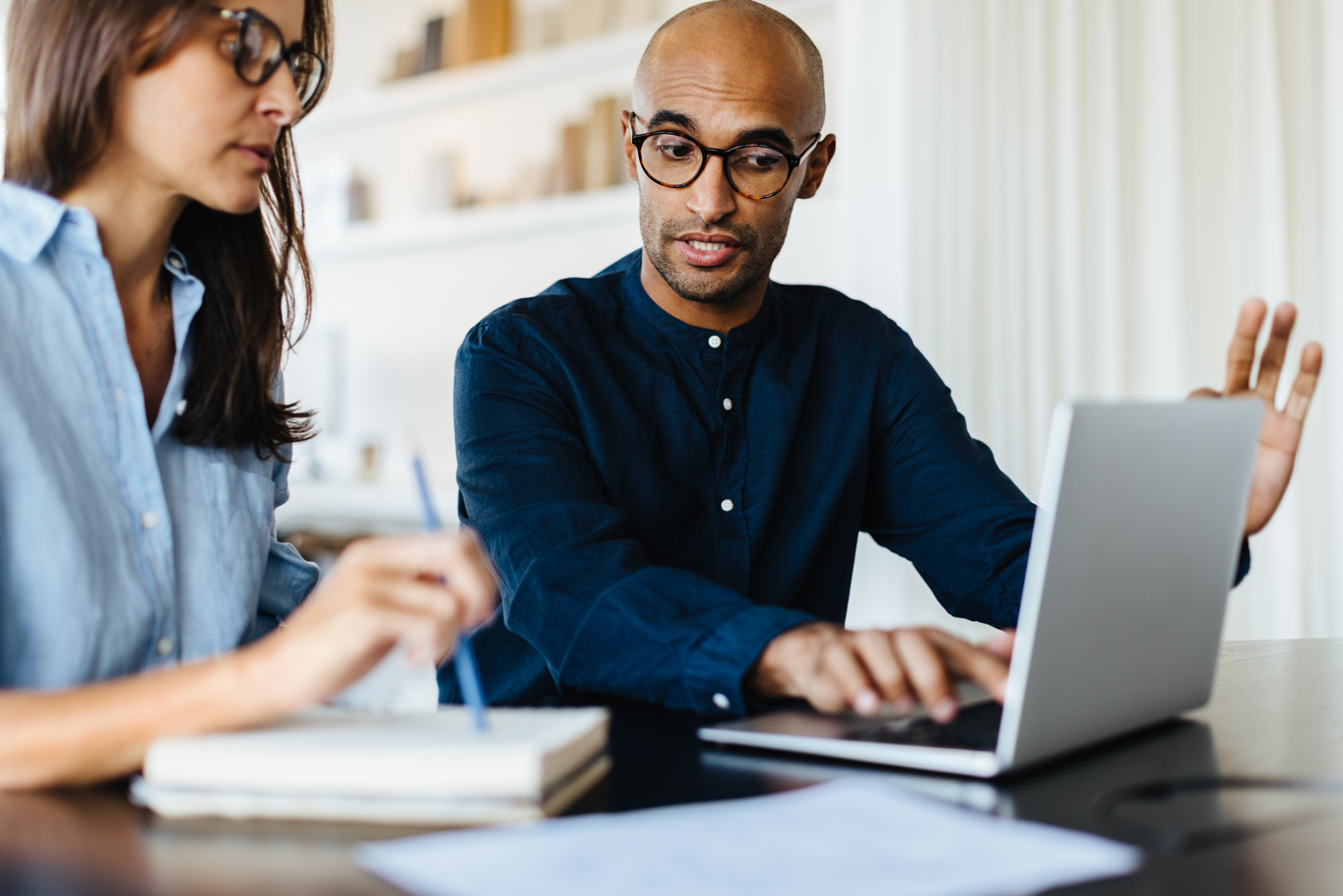 A man and woman sitting on a couch in an office, discussing work together